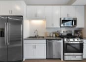 Thumbnail 7 of 105 - a kitchen with stainless steel appliances and white cabinets