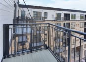 Thumbnail 82 of 105 - a balcony with a black railing and a white building in the background