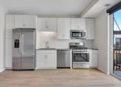 Thumbnail 80 of 105 - a kitchen with white cabinets and stainless steel appliances