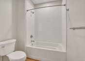 Thumbnail 78 of 105 - a bathroom with a white toilet and a white tub with a shower curtain