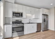 Thumbnail 73 of 105 - a kitchen with white cabinetry and stainless steel appliances