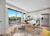 Thumbnail 50 of 105 - a living room and kitchen with a sliding glass door that leads to a balcony