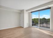Thumbnail 69 of 105 - a bedroom with a sliding glass door and hardwood floors
