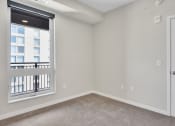Thumbnail 64 of 105 - a bedroom with a large window and carpeted flooring