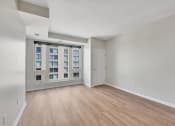 Thumbnail 62 of 105 - a bedroom with a large window and hardwood floors