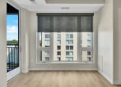 Thumbnail 63 of 105 - a bedroom with a large window and hardwood floors