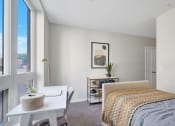 Thumbnail 27 of 105 - a bedroom with a large window and a desk with a chair