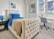 Thumbnail 26 of 105 - a bedroom with a bed and a desk with a chair