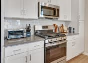 Thumbnail 11 of 105 - a kitchen with white cabinets and stainless steel appliances