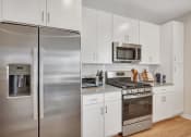 Thumbnail 12 of 105 - a kitchen with white cabinetry and stainless steel appliances