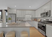 Thumbnail 30 of 105 - a kitchen with white cabinets and stainless steel appliances