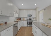 Thumbnail 33 of 105 - a large kitchen with white cabinets and stainless steel appliances