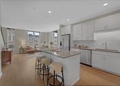 Thumbnail 29 of 105 - an open kitchen and living room with an island and stools