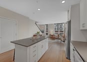Thumbnail 31 of 105 - a kitchen with white cabinets and a counter top and a refrigerator
