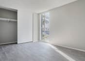 Thumbnail 30 of 39 - an empty living room with a window and a closet at The Arches Apartments, California, 92021