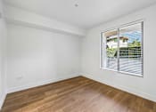 Thumbnail 44 of 60 - A room with wooden flooring and a window with blinds.