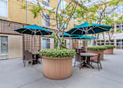 Thumbnail 19 of 23 - A Patio With Tables And Umbrellas at Atrium Garden Apartment Homes, LLC, San Jose, California