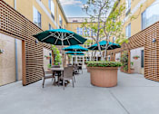 Thumbnail 14 of 23 - A Patio With Tables And Chairs And Umbrellas at Atrium Garden Apartment Homes, LLC, California