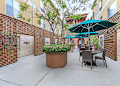 Thumbnail 7 of 23 - A Patio With Green Umbrella at Atrium Garden Apartment Homes, LLC, San Jose