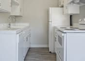 Thumbnail 26 of 39 - a white kitchen with a stove and a refrigerator at The Arches Apartments, El Cajon, 92021