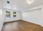 Thumbnail 43 of 60 - A room with wooden flooring and white walls.