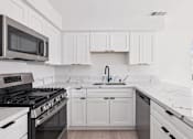 Thumbnail 26 of 45 - White Kitchen at Ocean Villas Apartments, Oxnard, California
