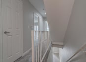 Thumbnail 11 of 23 - the landing of a staircase in a home with a white door at Warner Center Townhomes, Canoga Park California