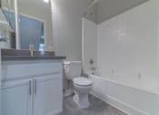 Thumbnail 13 of 23 - a bathroom with a toilet and a tub and a sink at Warner Center Townhomes, California