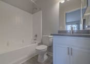 Thumbnail 14 of 23 - a bathroom with a toilet and a tub and a sink at Warner Center Townhomes, Canoga Park