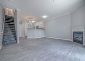 Thumbnail 7 of 23 - an empty living room with a fireplace and a staircase at Warner Center Townhomes, Canoga Park, CA 91303