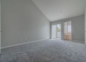 Thumbnail 21 of 23 - an empty living room with white walls and a door at Warner Center Townhomes, Canoga Park, CA