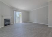 Thumbnail 9 of 23 - an empty living room with a fireplace and a sliding glass door at Warner Center Townhomes, Canoga Park, 91303