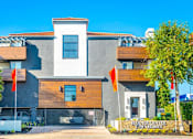 Thumbnail 2 of 23 - a house with two orange flags in front of it at Warner Center Townhomes, Canoga Park