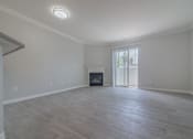 Thumbnail 10 of 23 - an empty living room with a fireplace and a sliding glass door at Warner Center Townhomes, Canoga Park, CA 91303