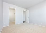 Thumbnail 14 of 47 - an empty living room with white walls and a closet at Skyline Heights Apartments, Daly City, CA