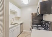 Thumbnail 4 of 47 - a kitchen with a stove and a sink and a microwave at Skyline Heights Apartments, Daly City, 94015