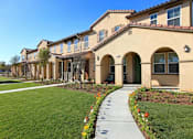 Thumbnail 11 of 45 - a sidewalk in front of a building with grass at The Vines at Riverpark, LLC, California, 93036
