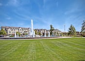 Thumbnail 13 of 45 - a fountain in the middle of a park with a building in the background at The Vines at Riverpark, LLC, Oxnard, 93036