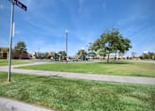 Thumbnail 20 of 45 - a park with a playground and a street sign at The Vines at Riverpark, LLC, California