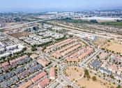 Thumbnail 24 of 45 - an aerial view of an urban area with buildings and roads at The Vines at Riverpark, LLC, Oxnard, CA