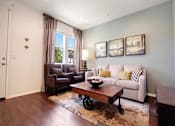 Thumbnail 10 of 45 - a living room with a couch and a table at The Vines at Riverpark, LLC, Oxnard, CA