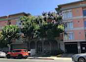 Thumbnail 10 of 23 - A Red Car Is Parked In Front Of a Building at Atrium Garden Apartment Homes, LLC, San Jose, CA