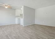 Thumbnail 17 of 39 - an empty living room and kitchen with a ceiling fan at The Arches Apartments, El Cajon, CA 92021