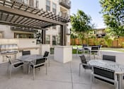 Thumbnail 9 of 60 - A patio with a table and chairs under a pergola. at Cirrus Redwood City Apartments, Redwood City, CA, 94061