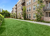 Thumbnail 17 of 60 - A long grass lawn in front of apartment buildings. at Cirrus Redwood City Apartments, Redwood City, CA, 94061