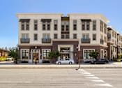Thumbnail 20 of 60 - A street view of a building with cars parked in front. at Cirrus Redwood City Apartments, Redwood City, California
