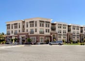 Thumbnail 19 of 60 - A large building with a parking lot in front of it. at Cirrus Redwood City Apartments, California, 94061