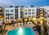 Thumbnail 7 of 60 - A swimming pool in front of apartment buildings at dusk. at Cirrus Redwood City Apartments, California