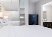 Thumbnail 9 of 21 - A bedroom with a large bed, a dresser, and a mirror. at The Maddox Sunnyvale Apartments, Sunnyvale, 94087