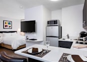 Thumbnail 1 of 21 - A modern kitchen and dining area with a bed and a refrigerator. at The Maddox Sunnyvale Apartments, California